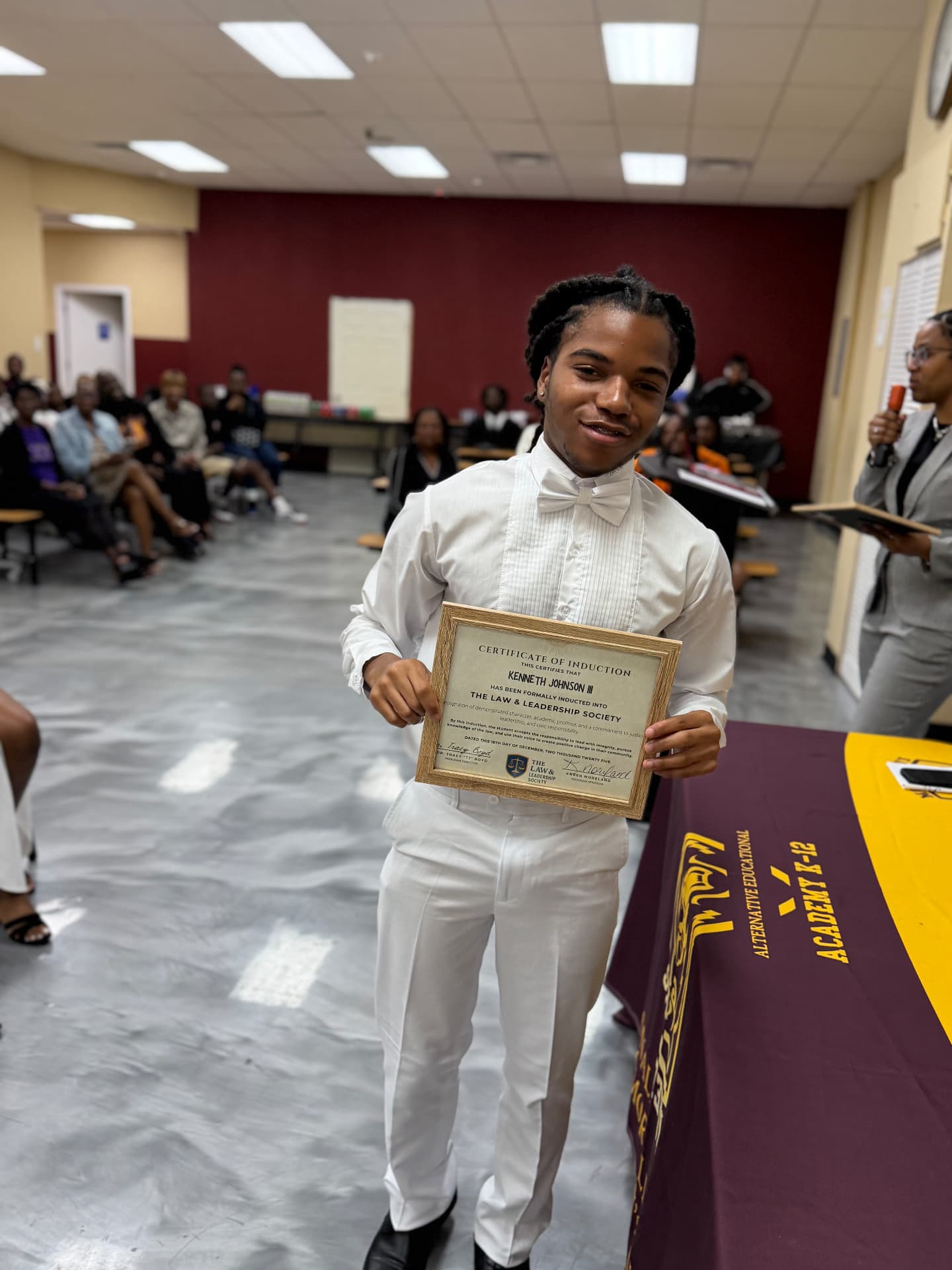 An LLS student holding a Law and Leadership Society induction certificate