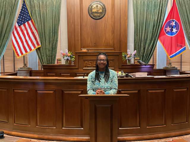An LLS student seated at a courtroom bench during a visit